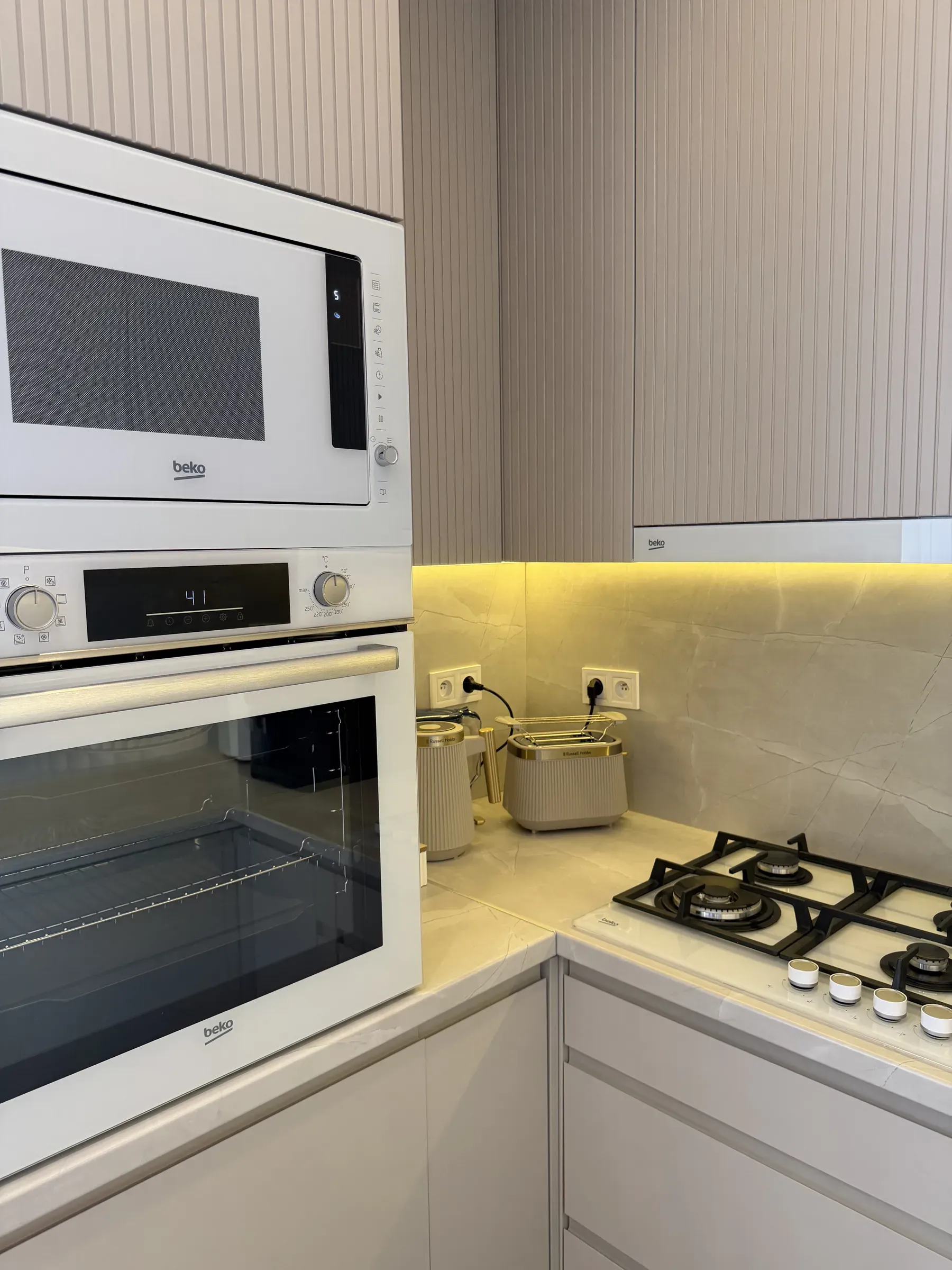 Piekarnik i mikrofalówka w zabudowie kuchennej apartamentu