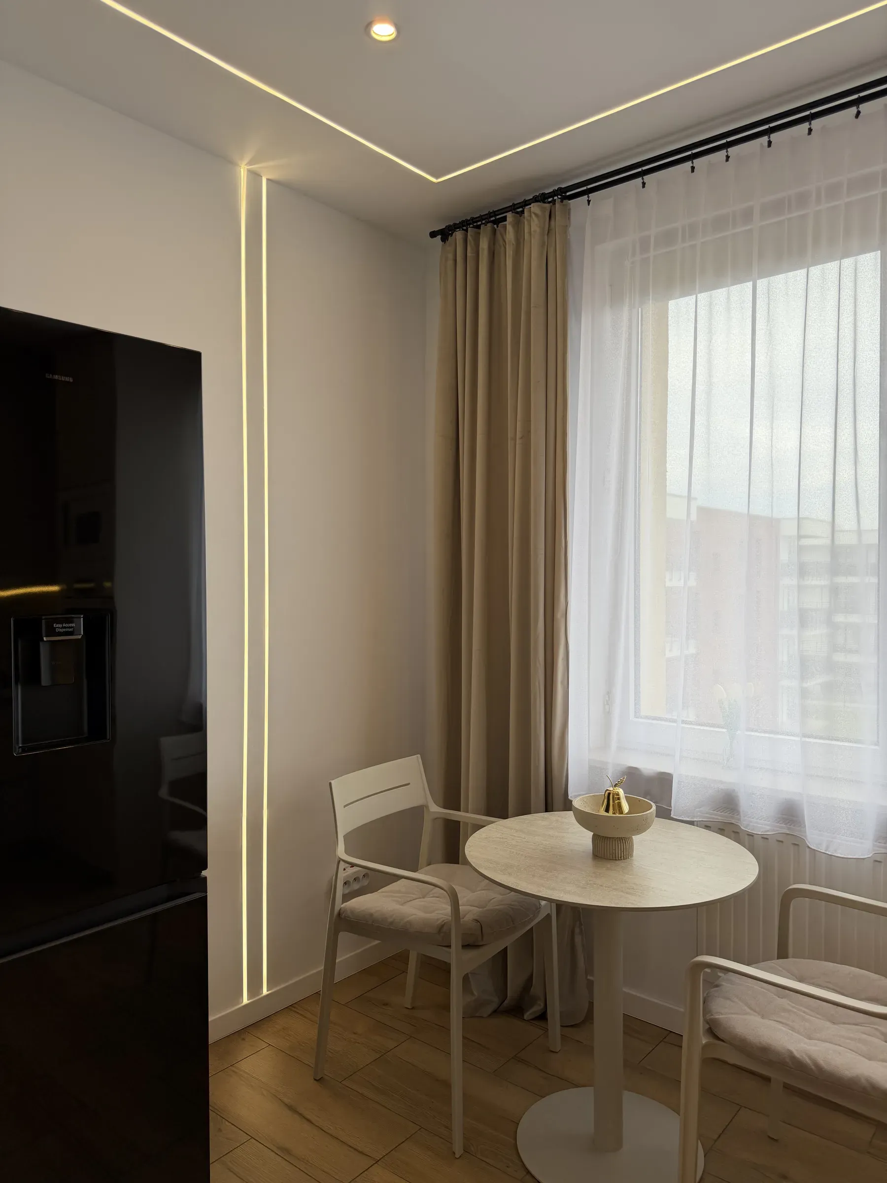 Stolik z krzesłami przy oknie, miejsce na posiłki w apartamencie