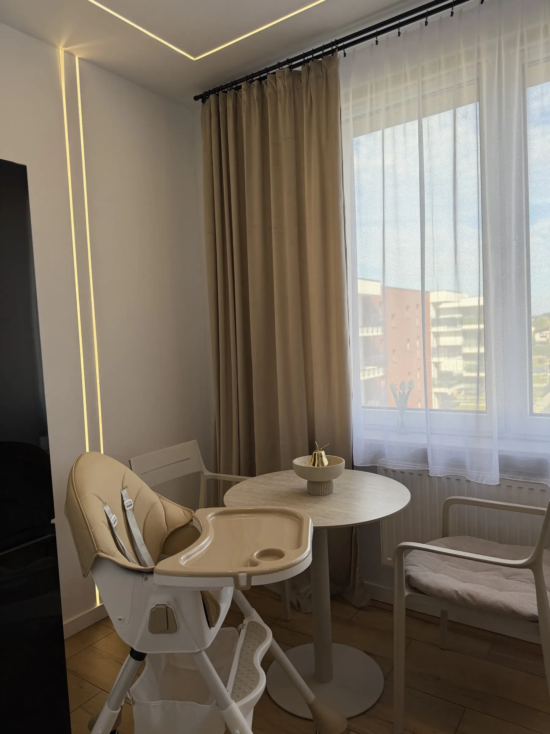 Krzesełko do karmienia przy okrągłym stoliku w apartamencie Helenka Modern w Zabrzu
