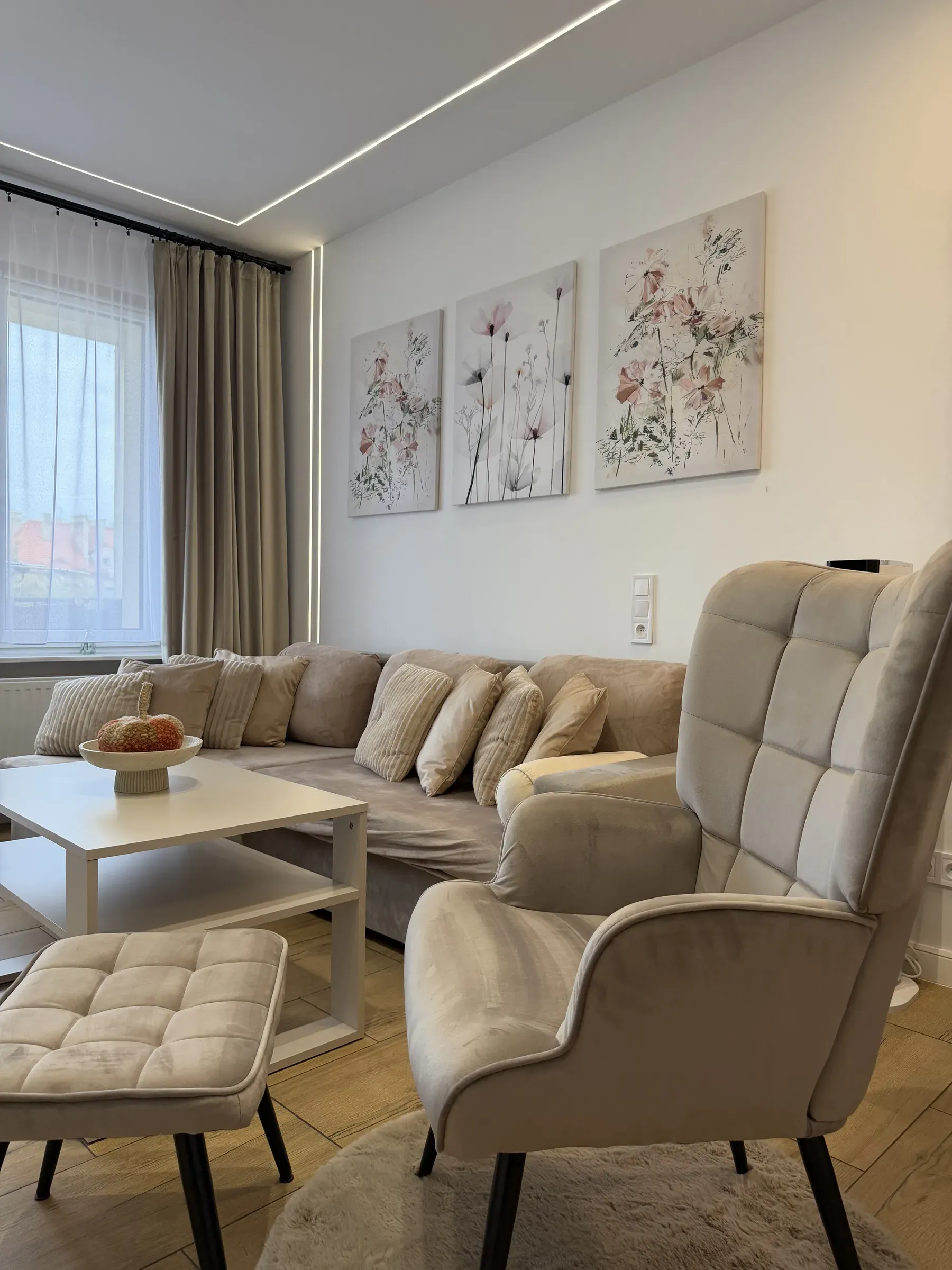 Fotel z podnóżkiem i stolik kawowy w salonie apartamentu Helenka Modern