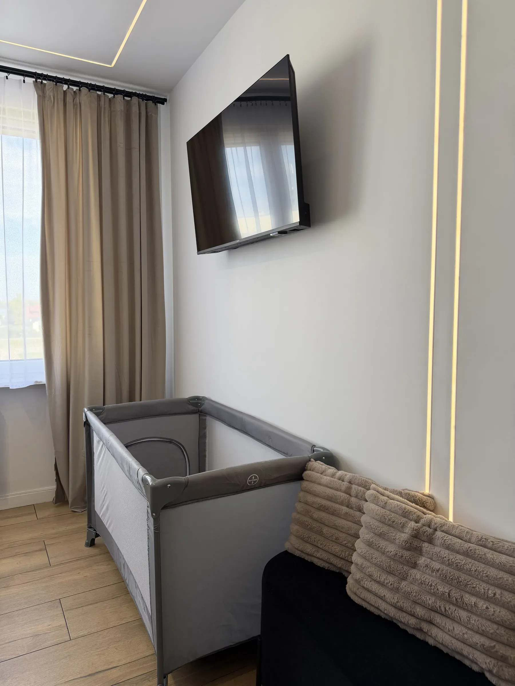 Łóżeczko turystyczne dla dziecka rozstawione w sypialni apartamentu Helenka Modern